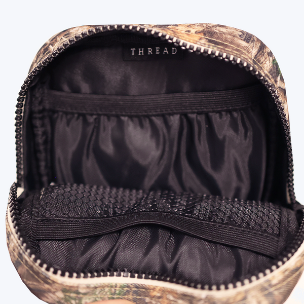 Inside of the Thread® Realtree Edge crossbody bag showing pockets and printed lining